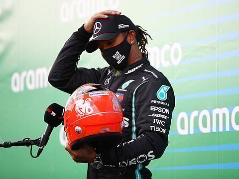 Mercedes' Lewis Hamilton receives one of Michael Schumacher's helmets from the German's son, Mick, after winning the Eifel Grand Prix.