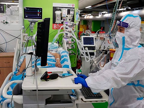 A member of the medical staff, wearing protective equipment, checks on a patients at the coronavirus ward of the Rambam Health Care Campus, initially build as an underground medical facility before being converted to a car park, which has been reconverted to receive patients as COVID-19 cases surge, in the northern Israeli city of Haifa on October 11, 2020. - Israel opened a new coronavirus treatment facility co-run by the army's medical corps, an unprecedented move for the military unit, aimed at bolstering an embattled healthcare system. The Jewish state currently has one of the world's highest daily coronavirus infection rates per capita, with the number of seriously ill patients steadily rising. The army-backed unit at the Rambam Hospital in the northern city of Haifa includes a control room where patients are monitored via video and an underground coronavirus ward that used to be a car park.
