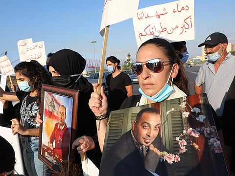 Women carrying pictures of family members killed in the massive August 4 explosion at Beirut's seaport, gather there to commemorate the second month after the disaster that killed at least 190, injured more than 6,500 and ravaged entire neighbourhoods of the Lebanese capital leaving scores of residents homeless.