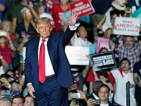 President Donald Trump waves to supporters as he leaves a campaign rally at the Orlando Sanford International Airport Monday, Oct. 12, 2020, in Sanford, Fla.