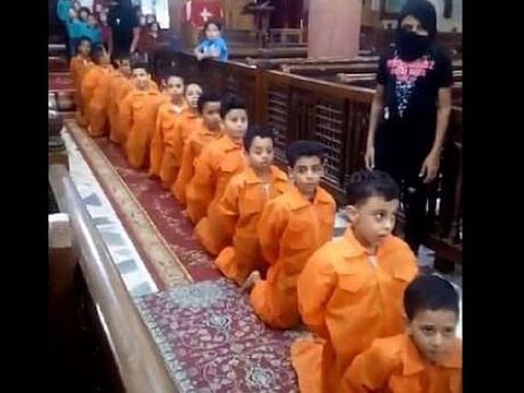 The children appear walking in a row with their hands tied behind their backs as part of the controversial execution show.