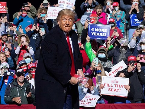 US President Donald Trump throws masks as he arrives to hold a Make America Great Again rally as he campaigns at John Murtha Johnstown-Cambria County Airport in Johnstown, Pennsylvania, October 13, 2020.
