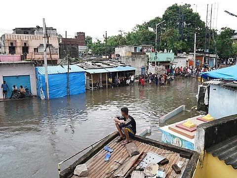 People seen in a flooded residential area after heavy rainfall in Hyderabad, the capital of the southern state of Telangana, India.