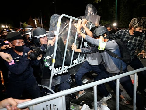 Pro-democracy protesters push Thai policemen with riot shields during a demonstration in Bangkok, Thailand, Thursday, Oct. 15, 2020.
