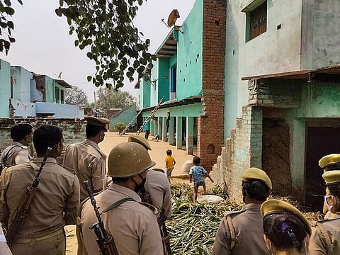 Police personnel stand guard as CBI officials (unseen) investigate the case of a 19-year-old Dalit woman who died after being allegedly gang-raped, in Hathras, Thursday, Oct. 15, 2020.