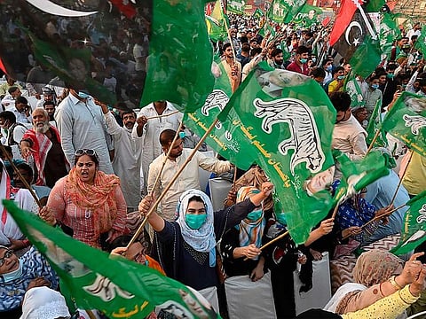Activists of the Pakistan Democratic Movement (PDM), an opposition alliance of 11 parties, wave party flags during the first public rally in the eastern city of Gujranwala on October 16, 2020.