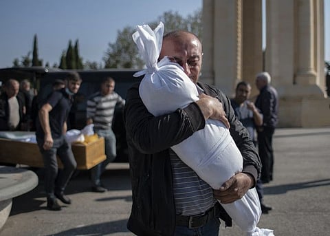 Timur Haligov, an Azerbaijani Turkish father embraces the body of his 10-month-old baby girl, Narin, who was killed by overnight shelling by Armenian forces during a funeral ceremony, in Ganja, Azerbaijan, Saturday, October 17, 2020.
