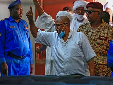 Omar Al Bashir, former Sudan president, gestures to supporters as he enters the court during his trial in Khartoum.
