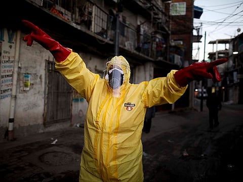 File picture: Jimena Aballe directs her neighbours as they disinfect their own streets in the Villa 31 neighbourhood to curb the spread of COVID-19 in Buenos Aires, Argentina in May 2020..