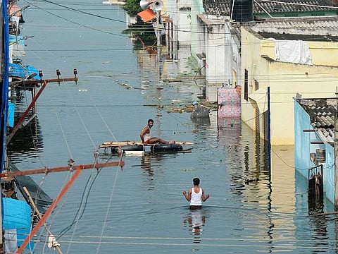 Flood-affected residents search for their belongings in a flooded housing colony following heavy rains on the outskirts of Hyderabad on October 20, 2020.