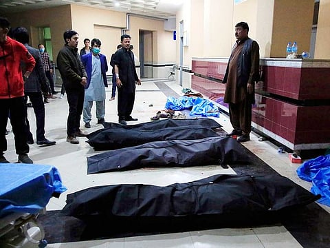 Afghan men look for their relatives at a hospital after a suicide attack in Kabul, Afghanistan, Saturday, Oct. 24, 2020.
