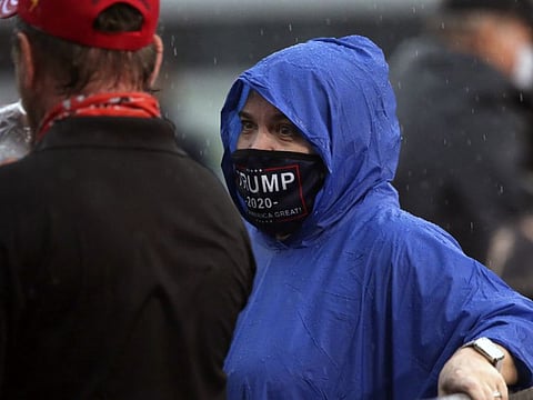 Mary Carr had on her face mask to show her support for Trump as she waits in the rain at a campaign rally to listen to Vice President Pence speak Saturday October 24, 2020 in Tallahassee, Florida.