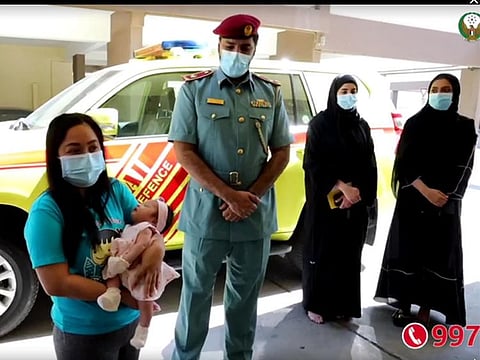 The mother and child with Dubai Civil Defence officials.