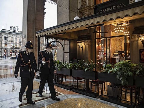Police officers wearing protective masks walk through the Galleria Vittorio Emanuele in Milan, Italy, on Monday, Oct. 26, 2020. Italy introduced its strongest virus restrictions since the end of a lockdown in May, and Spain will impose new measures, including a nationwide curfew.