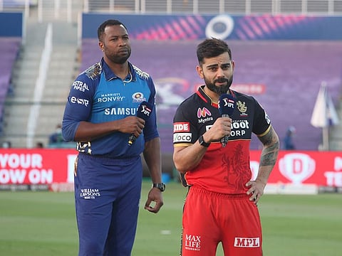 Kieron Pollard (left), who filled in as Mumbai Indians skipper due to Rohit Sharma's injury in the UAE last year, with counterpart Virat Kohli of Royal Challengers Bangalore.
