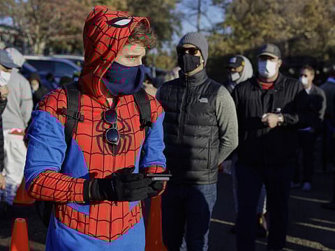 Colin Buckley of Omaha wears a Spiderman suit as he waits to cast an early vote on Halloween, at the Douglas County Election Commission office in Omaha, Nebraska, Saturday.