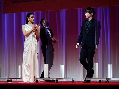Cast members Tao Tsuchiya and Exile Naoto from the movie 'Food Luck' enter between plastic walls on the stage, installed in order to prevent infections following the coronavirus disease (COVID-19) outbreak, as they attend the opening ceremony of the 33rd Tokyo International Film Festival, in Tokyo, Japan October 31, 2020.