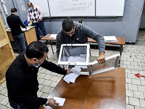 Poll station workers empty a ballot box to begin counting after a vote on a revised constitution ended at a station in Algeria's capital Algiers on November 1, 2020.