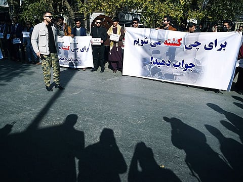 Students and civil society activists hold banners in protest as they shout slogans, a day after gunmen stormed Kabul university in Kabul on November 3, 2020
