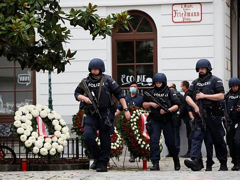 Police officers walk at the site of wreath laying ceremony after exchanges of gunfire in Vienna on Tuesday.