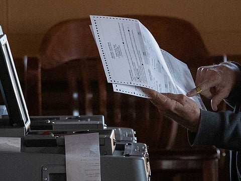 An election official points towards a mail in ballot while scanning votes for the 2020 U.S. presidential election in Marfa, Texas, U.S.