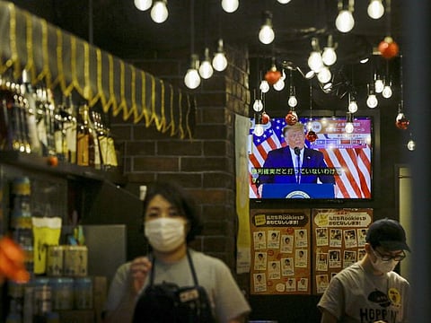 President Donald Trump speaking from the White House is projected on a television at a restaurant in Tokyo on Wednesday.