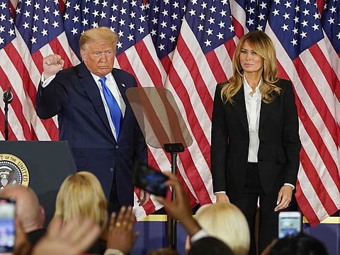 US President Donald Trump gestures after speaking during an election night party with U.S. First Lady Melania Trump, right, in the East Room of the White House in Washington, D.C., U.S., on Wednesday, Nov. 4, 2020. Trump declared he had won re-election against Joe Biden and said he would ask the Supreme Court to intervene, even as several battleground states continue to count votes.