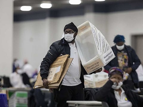 A worker with the Detroit Department of Elections carries empty boxes used to organise absentee ballots after nearing the end of the absentee ballot count at the Central Counting Board in the TCF Center on November 4, 2020 in Detroit, Michigan.