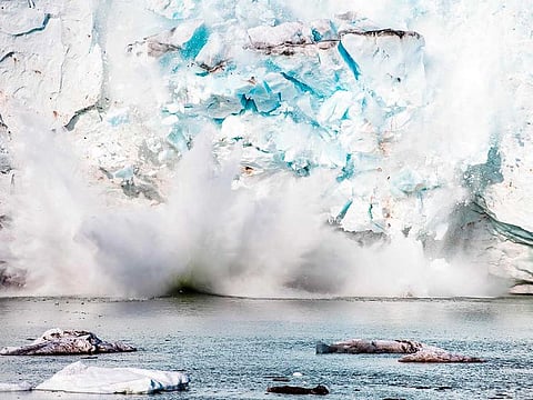 This file photo taken on August 17, 2019 shows an iceberg calving with a mass of ice breaking away from the Apusiajik glacier, near Kulusuk (aslo spelled Qulusuk), a settlement in the Sermersooq municipality located on the island of the same name on the southeastern shore of Greenland.