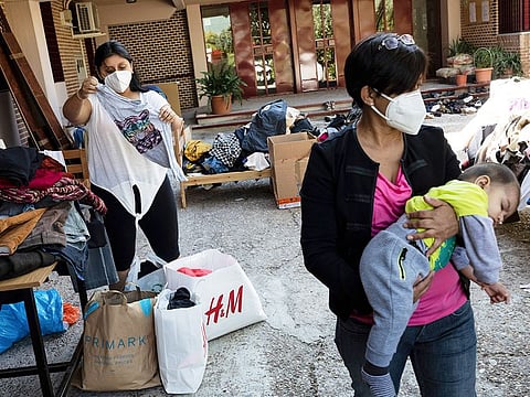 Residents of the southern neighbourhood of Vallecas pick clothes from a donation program at a Catholic parish in Madrid. Spain's government expects the economy to contract 11.2% this year, while the International Monetary Fund puts the drop at 12.8%, the highest rate among developed economies.
