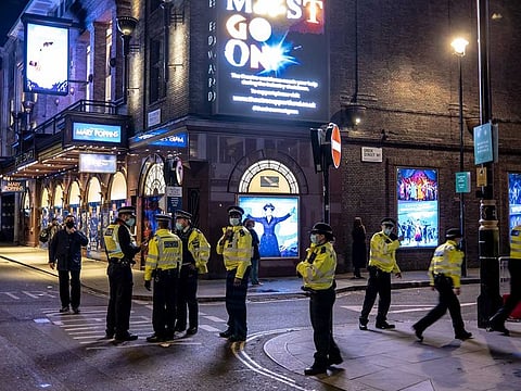 Police clear a street in London's Soho neighbourhood, after curfew on Wednesday evening, Nov. 4, 2020, in the hours before new lockdown restrictions were to be imposed in England.