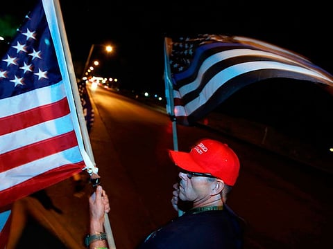 Donald Trump supporter Raul Latorre waves flags and joins others in protesting the Nevada vote outside Clark County Election Department on November 5, 2020, in North Las Vegas.