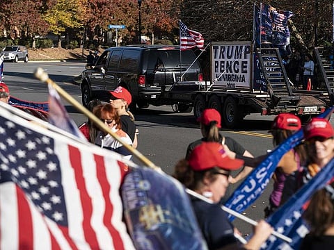 Supporters of US President Donald Trump gather as they wait for his departure from the Trump National Golf Club in Sterling, Virginia, U.S. on Sunday, Nov. 8, 2020. Joe Biden is moving forward as the president-elect, launching his transition effort and preparing a plan to curb the coronavirus pandemic while Trump weighs legal challenges and has so far refused to concede.