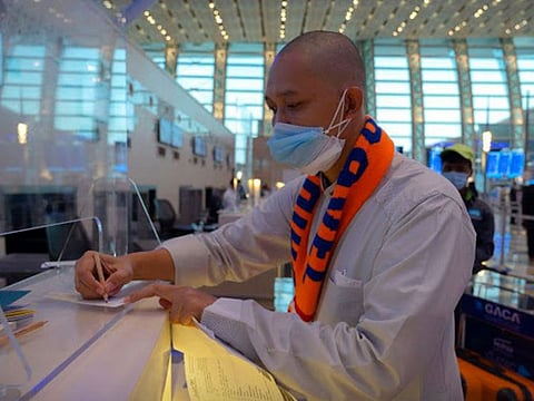 An Indonesian pilgrim handles departure procedures in Saudi Arabia.