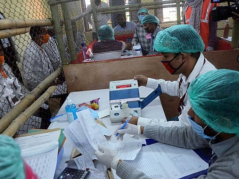 Election officials wearing masks carry out counting of votes for Bihar Assembly polls results, at a counting centre in Patna on Tuesday, November 10, 2020.