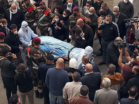 Paramedics move the body of Saeb Erekat past mourning family members, presidential guards, and journalists, toward a hospital morgue, in the West Bank city of Ramallah, Tuesday, Nov. 10, 2020.