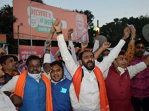 National Democratic Alliance workers celebrate their party leads in Bihar Assembly elections, in Patna, India on Tuesday.