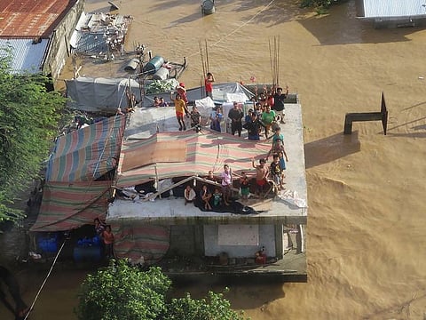 Residents sheltering on the roof of their flooded house in Cagayan province, north of Manila, on November 14, 2020, days after Typhoon Vamco hit parts of the country bringing heavy rain and flooding.