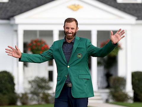 Dustin Johnson reacts after being presented his first green jacket after winning the Masters golf tournament Sunday, Nov. 15, 2020, in Augusta, Georgia.
