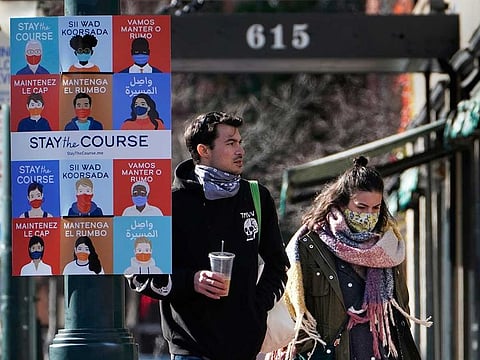 A sign in multiple languages encourages citizens to wear face coverings to help prevent the spread of COVID-19 in Portland, Maine.