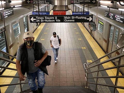 Commuters walk on a nearly empty subway platform in New York.
