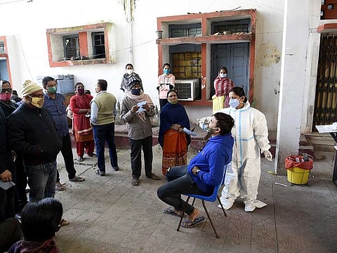 A health worker collects swab samples from people for the COVID-19 test, in Patna on Tuesday, November 24.