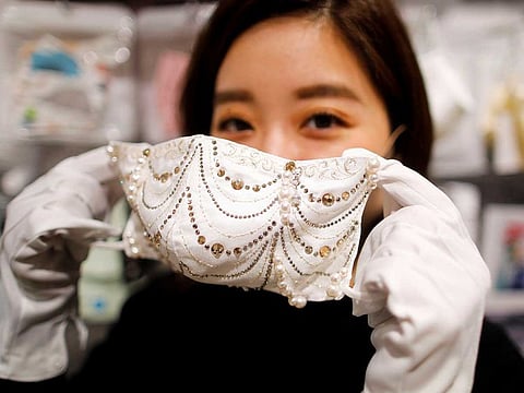An employee of Cox Co, the operation company of the face-mask speciality shop Mask.com, shows off a luxury face mask decorated with the diamond, platinum and Swarovski crystals which is selling for one million yen ($9,640), at the shop, amid the coronavirus disease (COVID-19) outbreak, in Tokyo, Japan November 25, 2020.