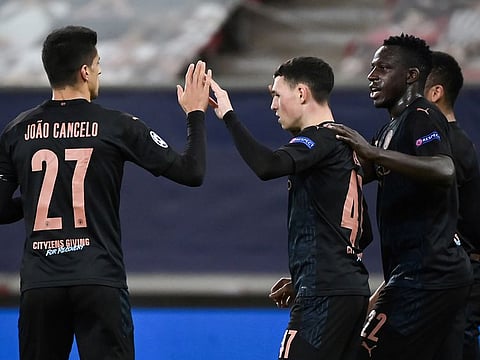 Manchester City's Phil Foden (C) is congratulated by teammates after scoring.