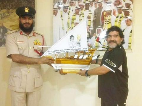 Diego Maradona receives a gift on his visit to Dubai Central Jail in 2011.
