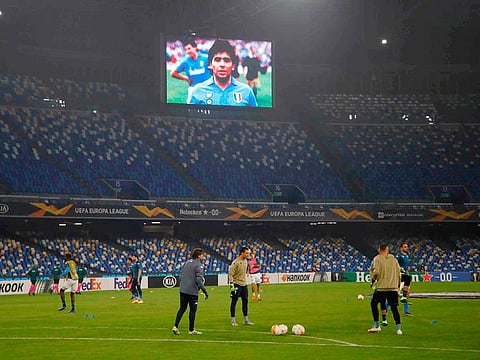 The giant screen at Napoli's stadium flashes an image of Argentine soccer legend Diego Maradona, as the team's players warm up before their Europa League match on Thursday.