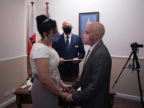 Brazilians Bruno Miani and Natalia Senna Alves de Lima (L) get married at the Civil Status and Registration Office in Gibraltar on November 24, 2020. Gibraltar has become Europe's hotspot to tie the knot during the coronavirus pandemic.