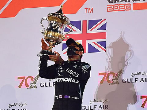 Mercedes' Lewis Hamilton celebrates with the trophy on the podium after winning the Formula One F1 Bahrain Grand Prix.