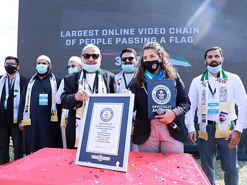 Dr P.A. Ibrahim Haji, chairman of Pace Education Group receives the Guinness World Record citation for the largest online video chain of people passing a flag.