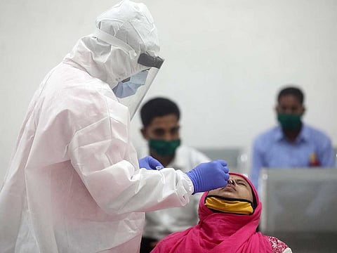 A health worker in a personal protective equipment (PPE) collects a swab sample from a woman amid the spread of the coronavirus disease (COVID-19) in Mumbai, India, December 1, 2020.
